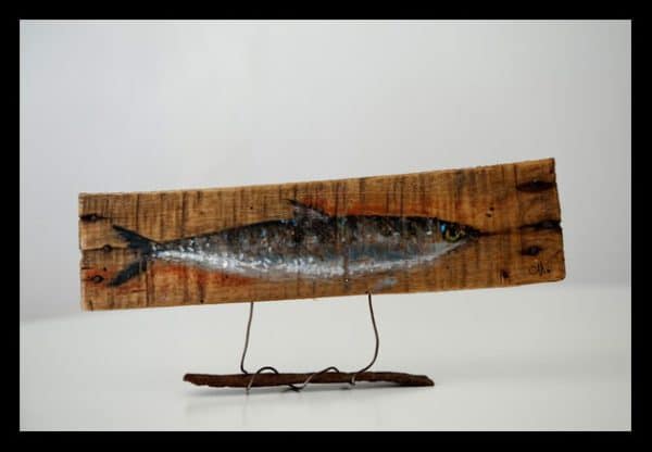 Ecological Artwork like this sardine-themed wall art piece are made with upcycled materials, such as pallet wood, rebar, wire and more.